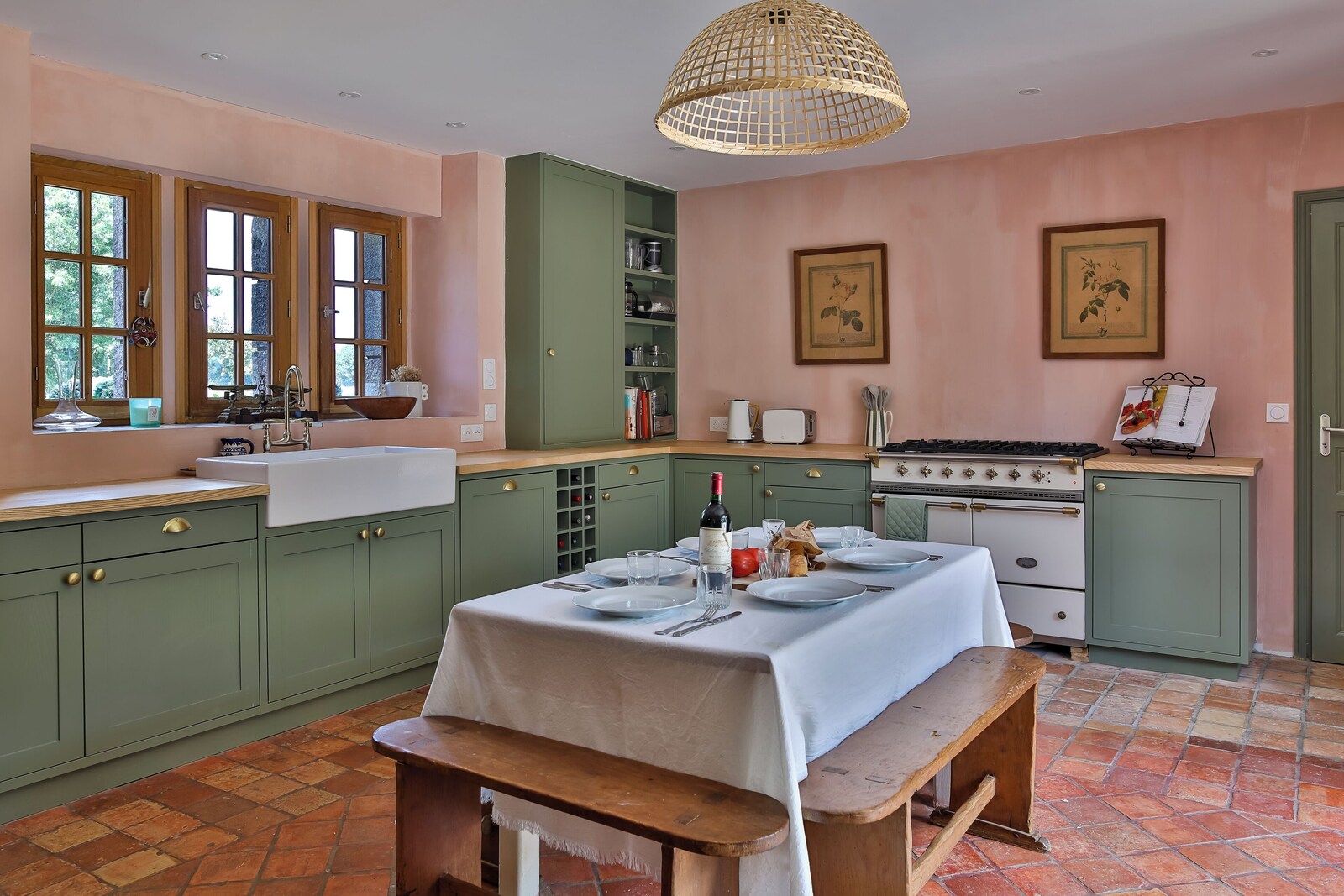 La cuisine du Cholo, avec mobilier sauge, murs roses et piano Lacanche